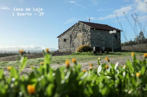 奥利维拉多霍斯比托Vila da Laje - Onde a Natureza o envolve - Serra da Estrela的花田里的古老石谷仓