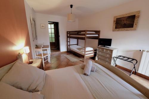 马西亚克la Ferme de Vazerat的一间卧室配有一张床、一张桌子和一张双层床。