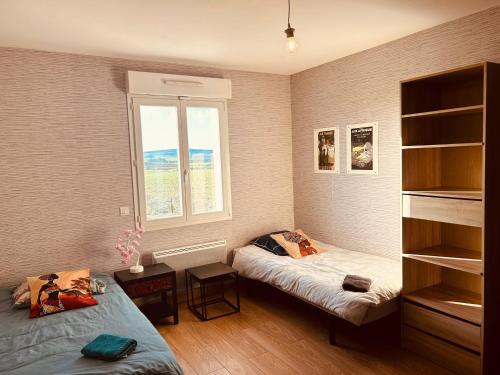 LA MARIEFACTURE - Comme un Tour du Monde的一间卧室设有两张床和窗户。