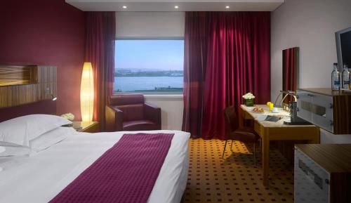 利物浦利物浦丽笙酒店的配有一张床、一张书桌和一扇窗户的酒店客房