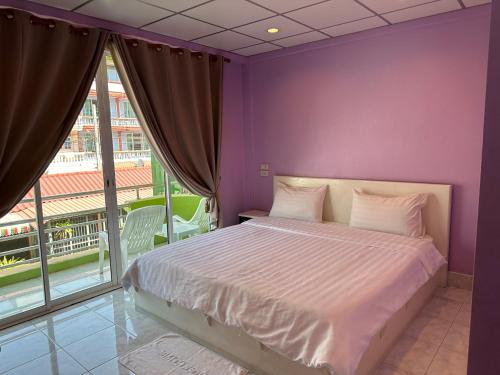 七岩Baan Keang Talay Cha Am的紫色卧室设有一张床和一个大窗户