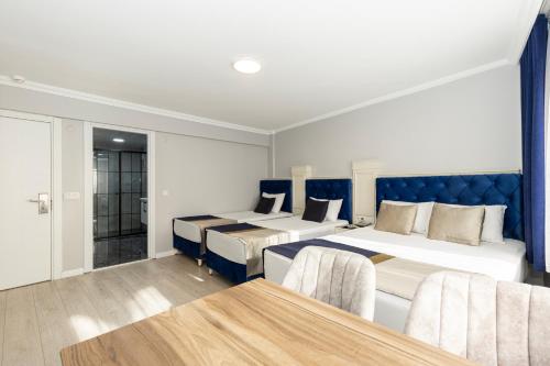 伊斯坦布尔Sirkeci Grand Family Hotel & SPA的酒店客房设有两张床和一张桌子。