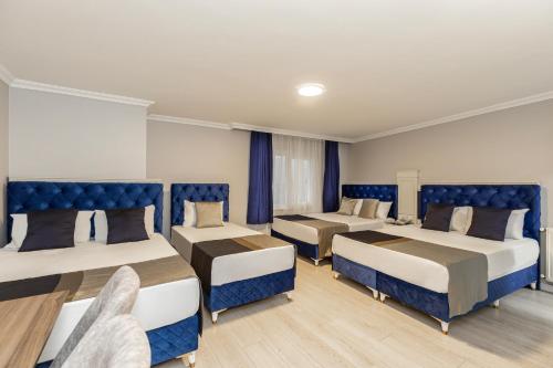 伊斯坦布尔Sirkeci Grand Family Hotel & SPA的带3张蓝色座椅的床的房间