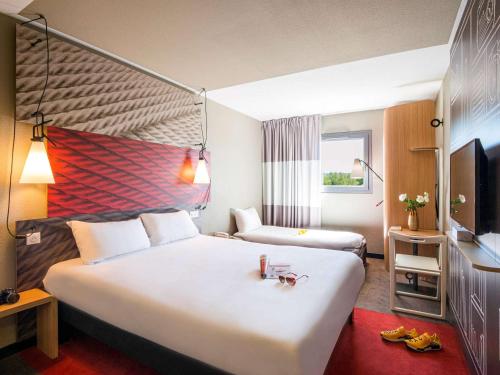 波尔多波尔多中心巴斯蒂德宜必思酒店的酒店客房设有一张大床和一台电视。