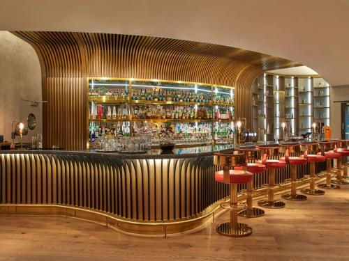 布鲁塞尔布鲁塞尔欧洲索菲特酒店的一间酒吧,在一间房间里设有一大堆酒吧凳