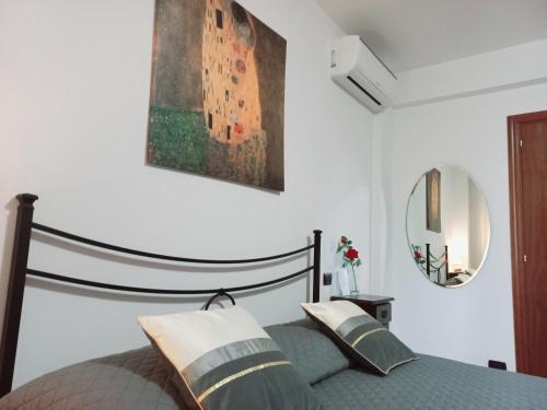 奥西莫B&B ROSE OSIMO的卧室配有一张床,墙上挂有绘画作品