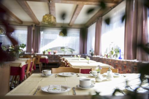 西兰德罗索能伯格旅馆的用餐室设有桌椅和窗户。