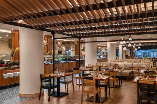 坎昆Hilton Cancun Mar Caribe All-Inclusive Resort的一间带木桌椅的餐厅和一间酒吧
