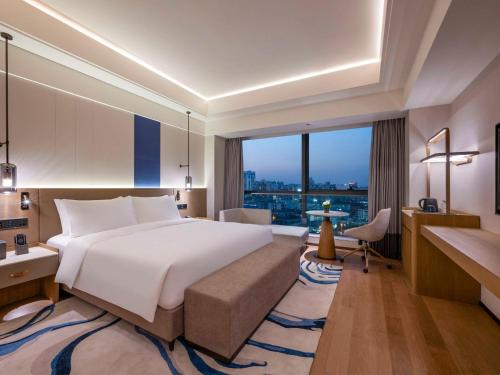 上海上海静安诺富特酒店的一间卧室设有一张大床和一个大窗户