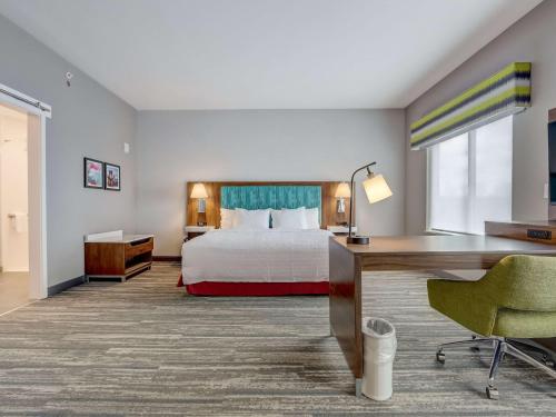 辛辛那提Hampton Inn & Suites Cincinnati Midtown Rookwood的配有一张床和一张书桌的酒店客房