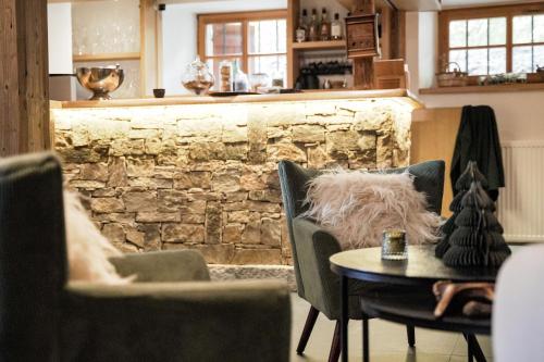 圣热尔韦莱班库佩林费尔梅餐厅酒店的一间设有椅子和桌子的房间,以及石墙