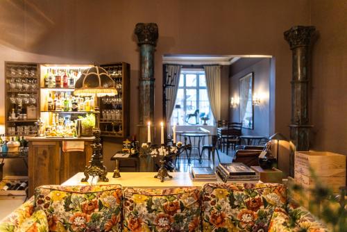 奥胡斯普罗旺斯别墅酒店的一间配有沙发的房间和一间带桌子的酒吧