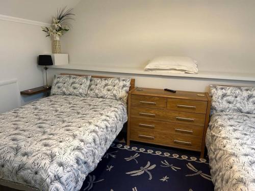 锡廷伯恩Alpaca Lodge的一间卧室配有一张床,梳妆台配有梳妆台