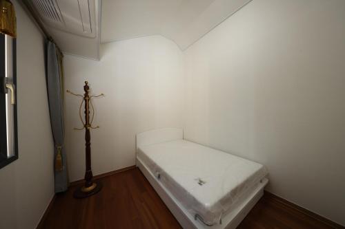 扶余Park Art Villas的小房间,角落里设有一张白色的床