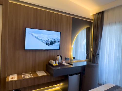 阿克恰阿巴德Sera Lake Center Hotel的酒店客房的墙上配有电视