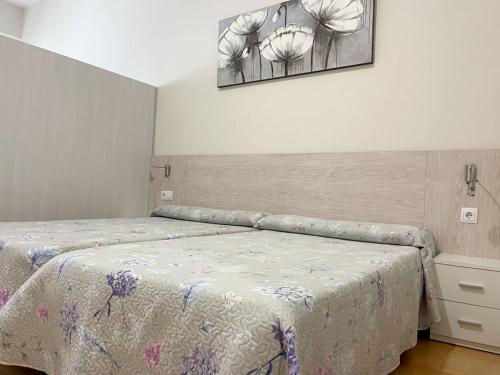 卡塔赫纳地中海之旅公寓酒店的卧室配有一张床,墙上挂着一幅画