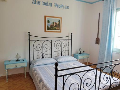 TrieiLocanda D'Ogliastra,的一间卧室配有床和两张蓝色的桌子