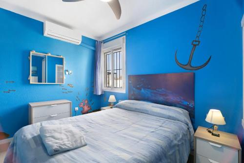 罗塔El Marinero的一间蓝色卧室,配有一张床和一个吊灯