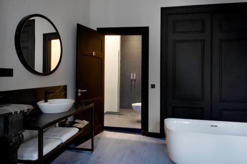 阿姆斯特丹Catalonia Vondel Amsterdam的带浴缸、水槽和镜子的浴室