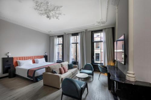 阿姆斯特丹Catalonia Vondel Amsterdam的酒店客房,配有床和沙发