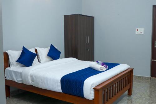 黎明之村Bay Walk Residency的一间卧室配有一张带蓝色和白色枕头的床