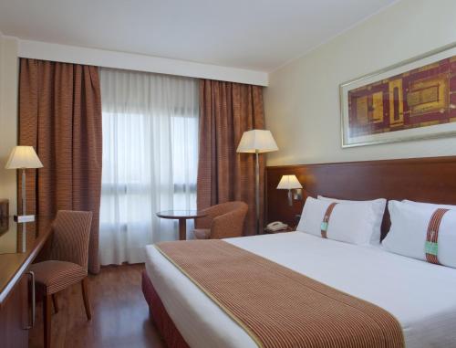 卡利亚里卡利亚里假日酒店的一间设有大床和窗户的酒店客房