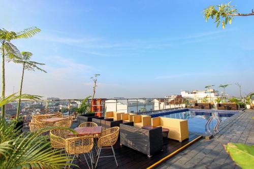 日惹Hotel FortunaGrande Malioboro Yogyakarta的一个带桌椅的阳台和一个游泳池