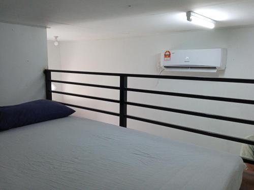 瓜拉丁加奴Tiny House Idaman Kuala Terengganu with Private House的一间卧室配有一张床和一个黑色栏杆