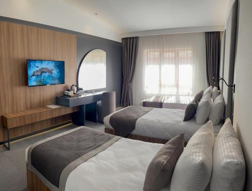 特拉布宗Sera Lake Center Hotel的酒店客房配有两张床和一张书桌