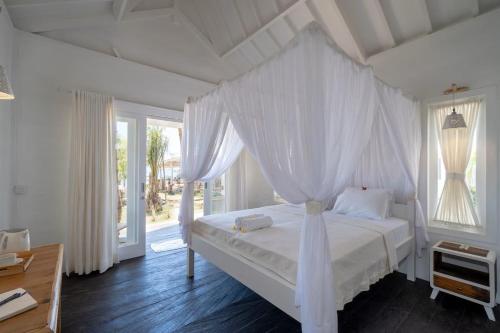 蓝梦岛Paus Putih Hotel的一间卧室配有一张带天蓬的白色床