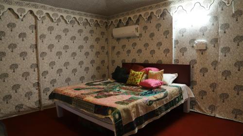 斋浦尔Elefantastic的卧室配有带枕头的床铺和窗户。