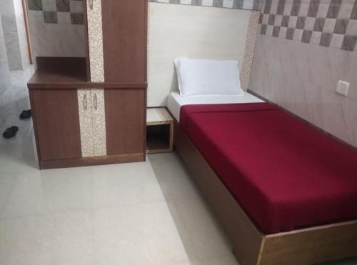 钦奈Surya's Guest House的小房间设有一张红色床垫的床