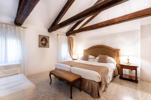 威尼斯圣特奥多罗宫 - 豪华公寓的一间卧室配有一张大床和一把椅子