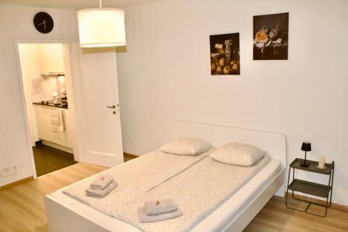 苏黎世Apartments zum Bühlhof (Julie)的白色卧室配有带2条毛巾的床
