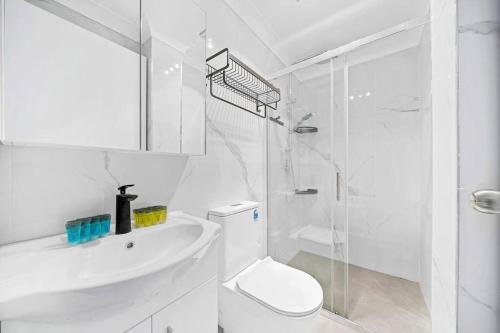 悉尼Modern 4B2B house@Glebe的白色的浴室设有卫生间和淋浴。