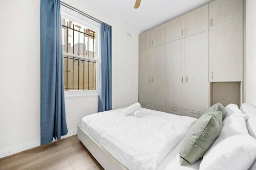 悉尼Modern 4B2B house@Glebe的卧室设有一张白色大床和一扇窗户。