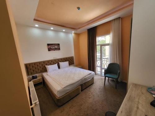 巴库Venera Hotel的卧室配有床、椅子和窗户。