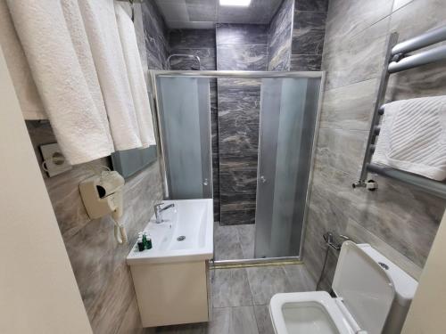 巴库Venera Hotel的带淋浴、盥洗盆和卫生间的浴室
