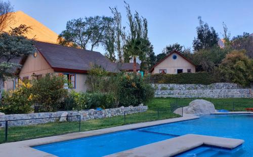 皮斯科艾齐Cabañas Las Gredas SPA Pisco Elqui的房屋前设有游泳池的房屋