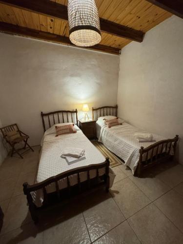 科洛尼亚-德尔萨克拉门托Lo de Adela Incluye 2 bicis的一间卧室配有两张床和吊灯。