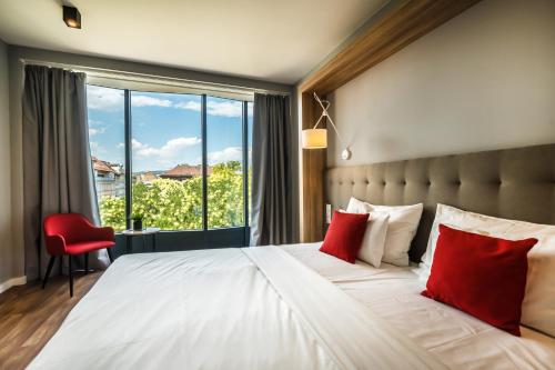 布达佩斯Up Hotel Budapest的一间卧室配有一张带红色枕头的大床