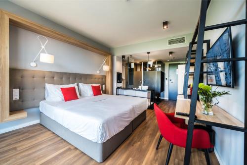 布达佩斯Up Hotel Budapest的一间卧室配有一张床和一张红色椅子