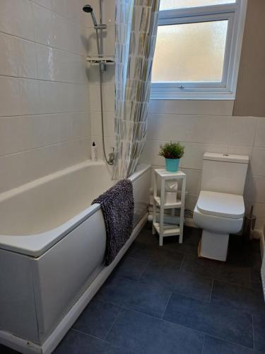 法弗舍姆Home from Home的浴室配有白色浴缸和卫生间。