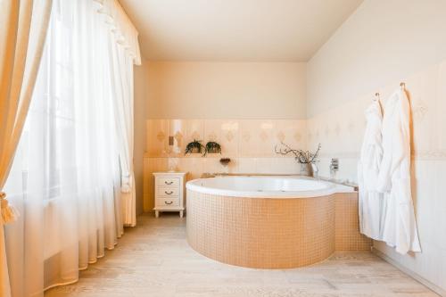 MostkoviceHotel Plumlov的带浴缸和淋浴帘的浴室