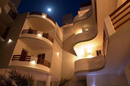 萨尔雷Apart-Hotel Ca Elsa的一座大型白色建筑,晚上设有阳台