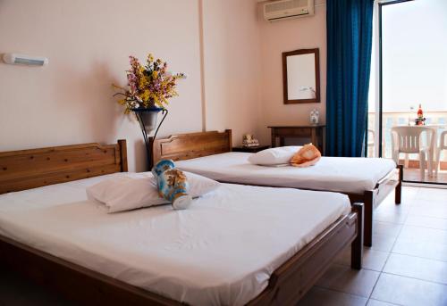 帕拉利亚卡泰里尼斯奥斯卡酒店的一间酒店客房,配有两张床,枕头上放着一只动物