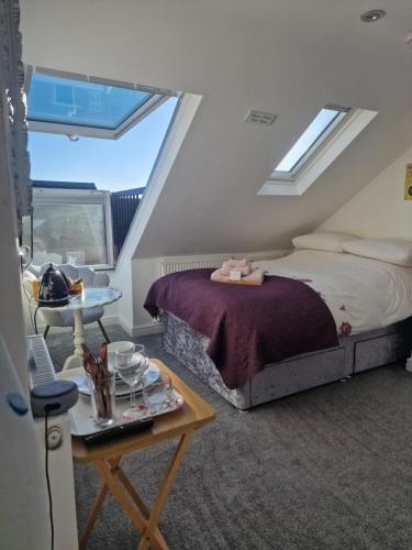 罗伊斯顿Redwing Rise的一间卧室配有一张床和一张桌子,并提供一个食品托盘