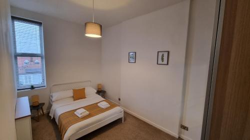 朴次茅斯Southsea Escape Coastal Apartment, 2 double bedrooms的白色的卧室设有床和窗户