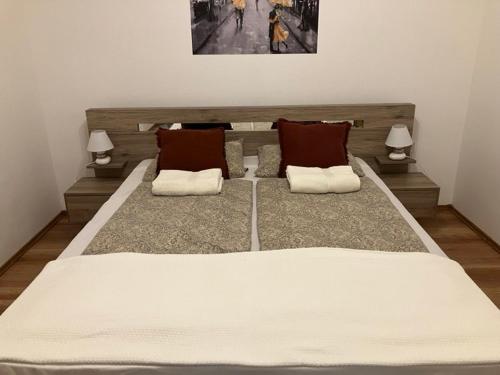 诺茨瓦约HUSZÁR VENDÉGHÁZ的卧室内的一张大白色床,配有两盏灯