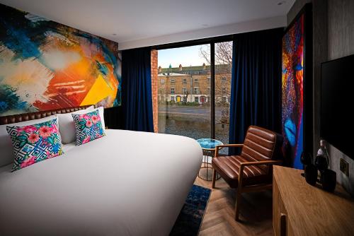 都柏林NYX Hotel Dublin Portobello的一间卧室设有一张大床和一个窗户。